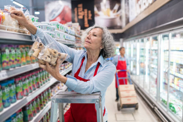senioren arbeiten im supermarkt - regalauffüller stock-fotos und bilder