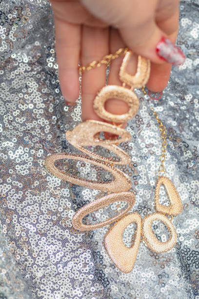 istock Hand holding Beautiful shiny golden asymmetric necklace 1210656828