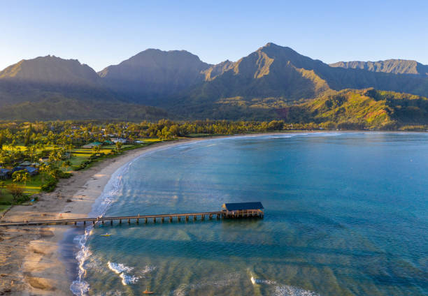 Aerial drone shot of Hanalei bay and beach on the north shore of Kauai in Hawaii Aerial panoramic image at sunrise off the coast over Hanalei Bay and pier on Hawaiian island of Kauai hanalei bay stock pictures, royalty-free photos & images