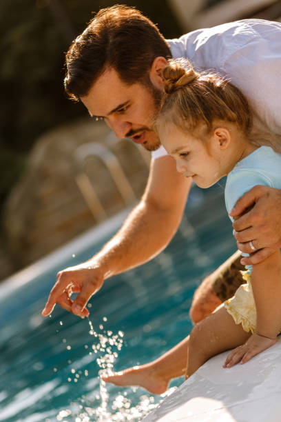istock Father showing girl something in the pool 1210658799