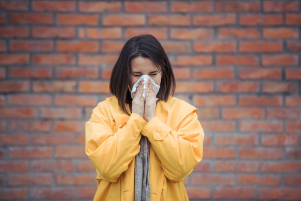 istock Sick young woman blowing her nose 1210658849