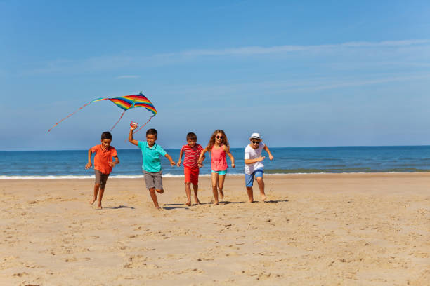 istock Many kids run on the beach with color kite 1210659160