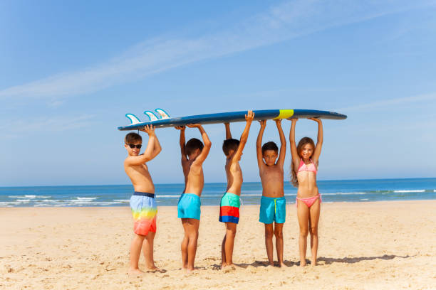 istock Five kids with surfboard on the sand sea beach 1210659172