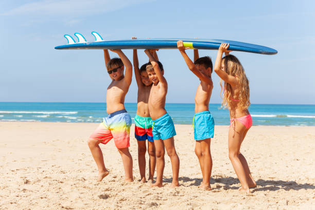 istock Kids portrait carry surfboard on the beach 1210659173