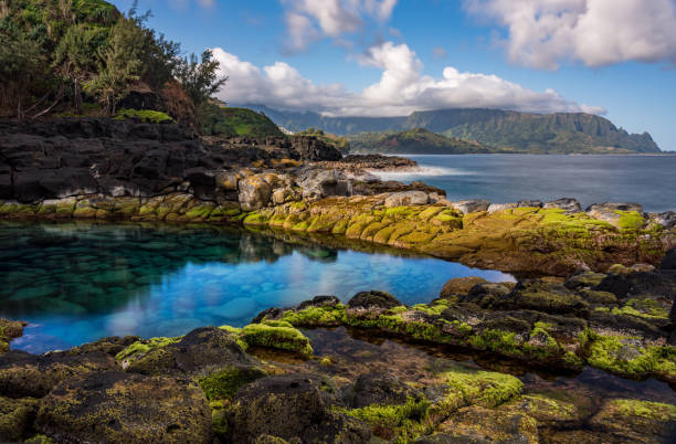 Long exposure image of the pool known as Queens Bath on north shore of Kauai Long exposure of the calm waters of Queen's Bath, a rock pool off Princeville on north shore of Kauai north shore stock pictures, royalty-free photos & images