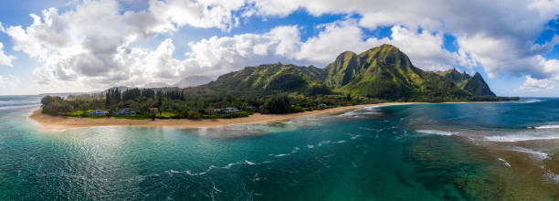 Aerial drone shot of Tunnels Beach on the north shore of Kauai in Hawaii Aerial panoramic image off the coast over Tunnels beach on Hawaiian island of Kauai with Na Pali mountains behind kauai photos stock pictures, royalty-free photos & images