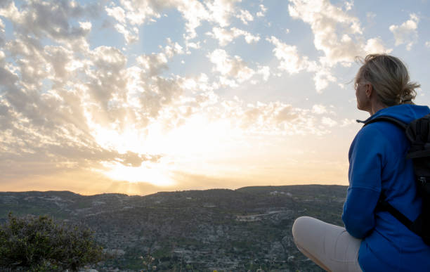 Mature female hiker looks off to view