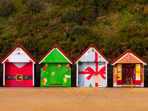 Bournemouth beach huts, sea and sand A row of colourful Christmas themed beach huts on the promenade at Bournemouth sea front sandbanks poole harbour stock pictures, royalty-free photos & images