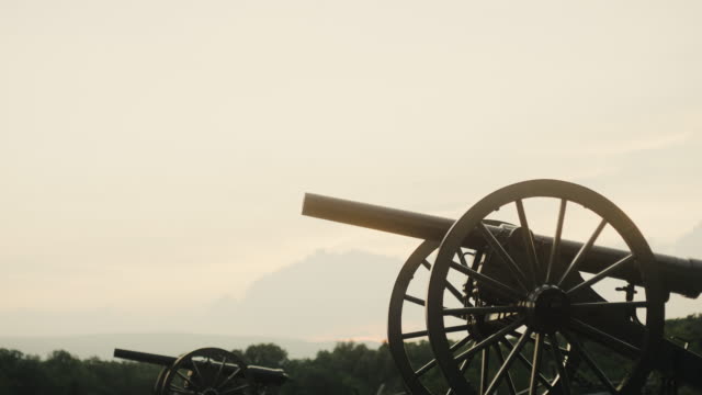 Tilting Down Shot of a Several US Civil War Cannons from Gettysburg National Military Park, Pennsylvania on a Hazy Day at Sunset