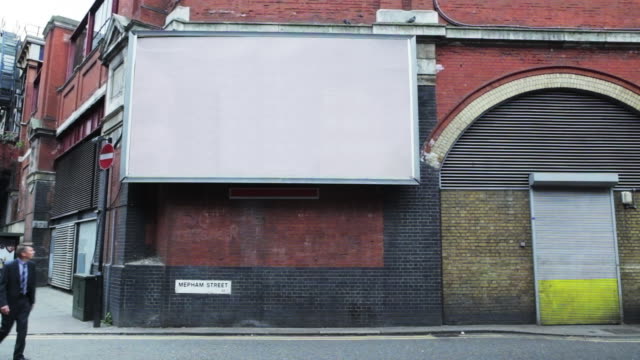 Businessman walking past blank billboard