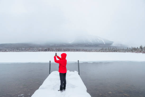 istock woman taking photo in snow 1210675377