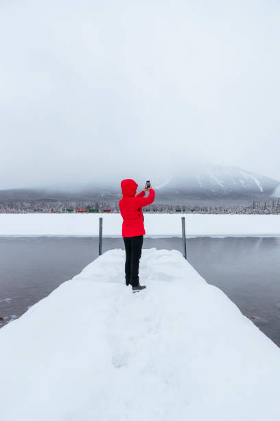 istock woman taking photo in snow 1210675431