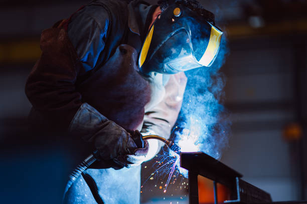 istock Industrial Welder With Torch and Protective Helmet 1210675463
