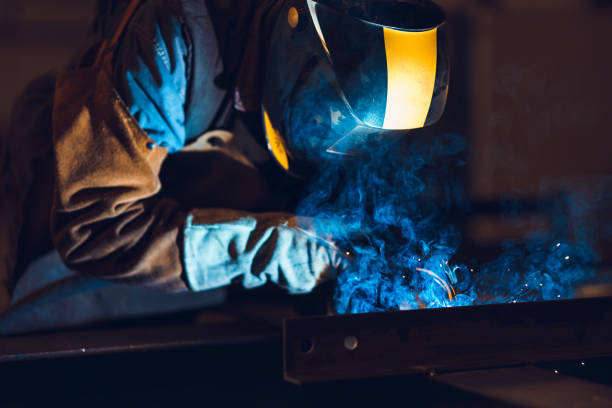 istock Industrial Welder With Torch and Protective Helmet 1210675497