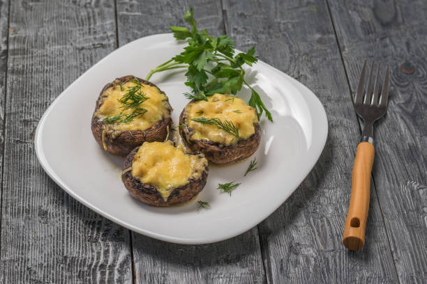 istock Baked Royal mushrooms on a white plate and a fork with a wooden handle. 1210675804