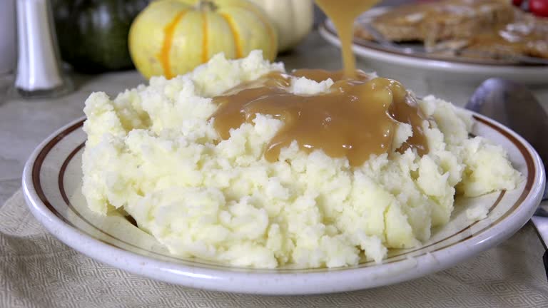 Pouring gravy over mashed potatoes slow motion