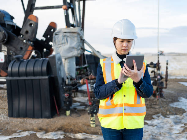 азиатская женщина-нефтяник с помощью планшетного пк - oil industry digital tablet manual worker mining стоковые фото и изображения