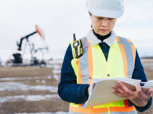 istock Female Oil Worker at oil field with folder 1210680514