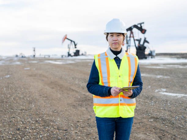 istock Female Oil Worker standing with tablet pc 1210680515