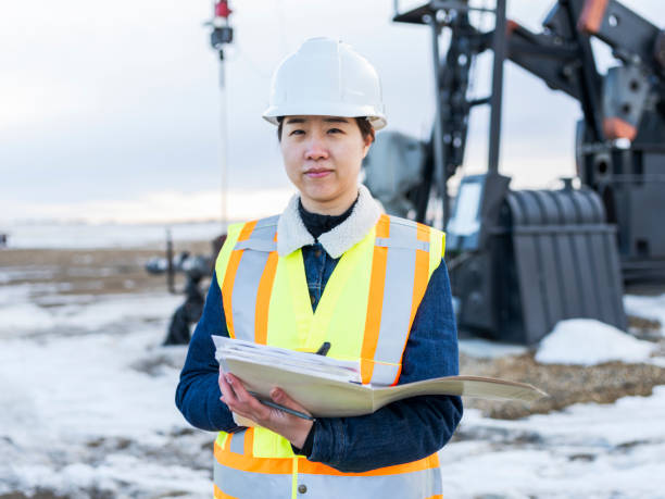 istock Female Oil Worker at oil field with folder 1210680538