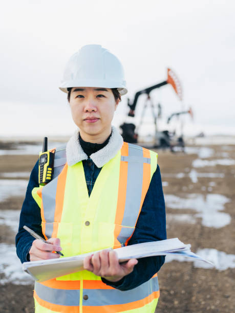 istock Female Oil Worker at oil field with folder 1210680575