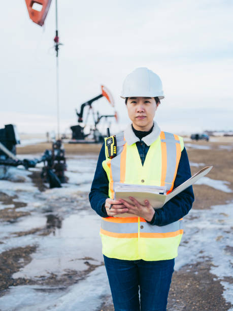 istock Female Oil Worker at oil field with folder 1210680593