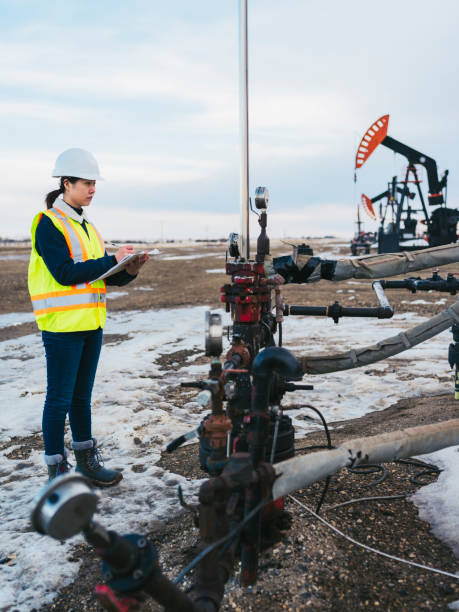istock Female Oil Worker at oil field with folder 1210680674