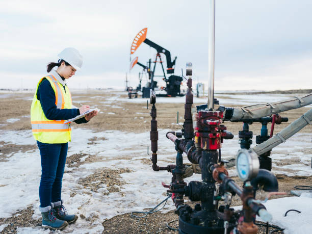 istock Female Oil Worker at oil field with folder 1210680675