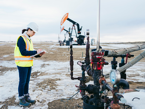 female oil worker working at oil field, Saskatchewan, Canada.