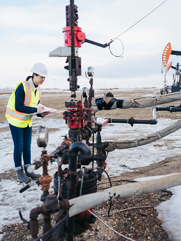 female oil worker working at oil field, Saskatchewan, Canada.