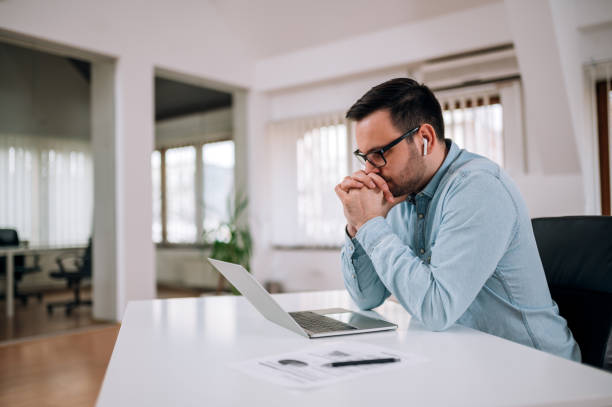 istock Worried entrepreneur looking at laptop screen at workplace, portrait. 1210684765