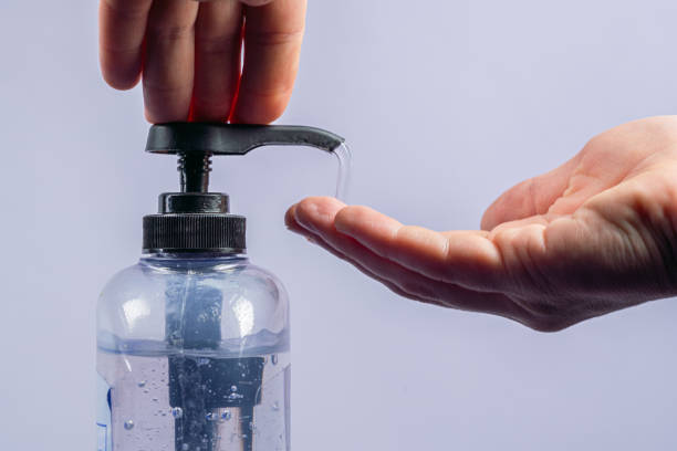 close-up shot of caucasian male hand pumping large flow of gel hand sanitizer with alcohol and aloe vera to prevent the spread of covid sars ncov 19 coronavirus swine flu h7n9 influenza illness during cold and flu season - flu virus cold and flu swine flu epidemic imagens e fotografias de stock