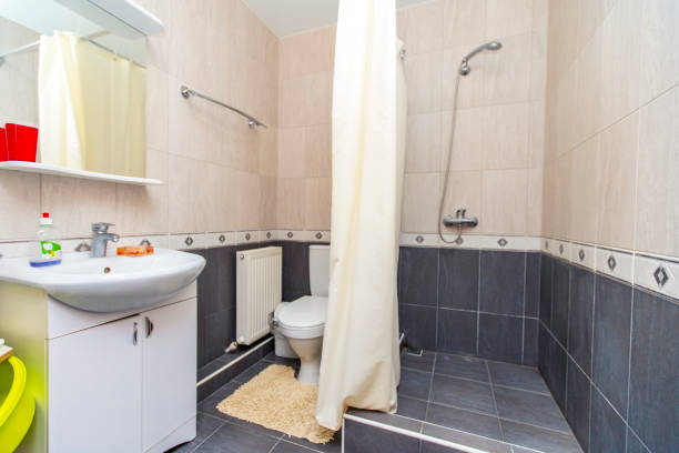 Shower room in the guest house. Beige tile on top, dark tile on the bottom. Shower and sink Shower room in the guest house. Beige tile on top, dark tile on the bottom. Shower and sink. guest bathroom stock pictures, royalty-free photos & images