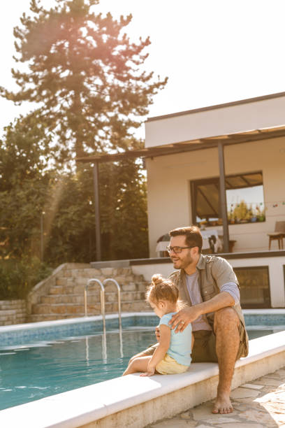 istock Father and daughter by the pool 1210697785