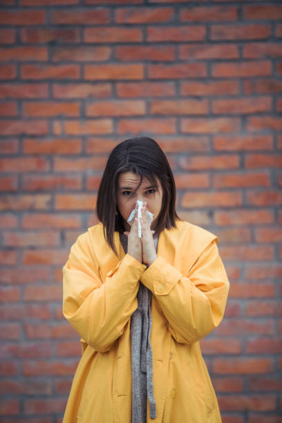 istock Sick young woman blowing her nose 1210697805