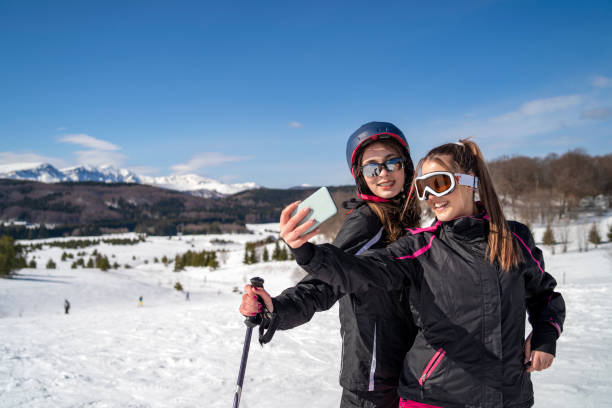 istock Two girls making selfie on the snow 1210700804
