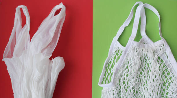 A string bag against plastic bags on a red and green background. Zero waste modern trendy concept, eco-friendly