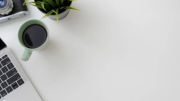 istock Top view of photographer workspace with  laptop, camera, coffee cup, tree pot and copy space 1210707745