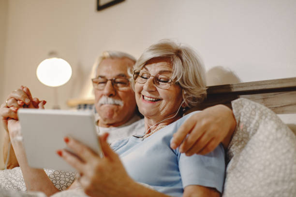 istock Happy senior woman and her husband using digital tablet in bedroom. 1210708390