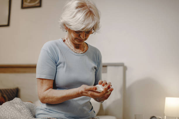 istock Mature woman taking her pills while preparing for bed. 1210709059