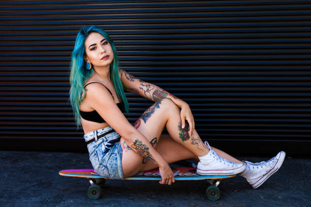 Girl with blue hair on her skateboard stock photo