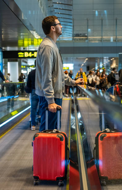 istock Man on moving walkway, moving sidewalk, moving pavement, autopedescalator, walkalator, travelator, horizontal escalator, slidewalk, or moveator at an airport. 1210715844
