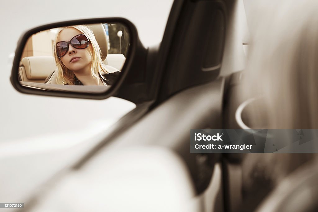 Giovane donna guardando in macchina specchio - Foto stock royalty-free di Adolescente