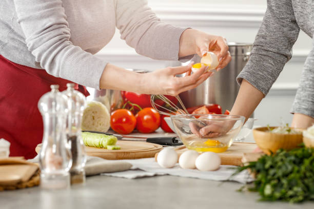 istock Chef`s hands working in the kitchen. Table background with kitchen tools and equipment and food products. Chef`s hands working in the kitchen. 1210724345