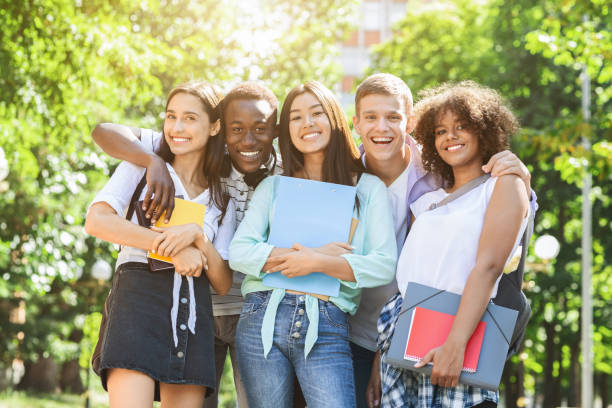istock Portrait of happy multicultural students posing at camera outdoors 1210730107
