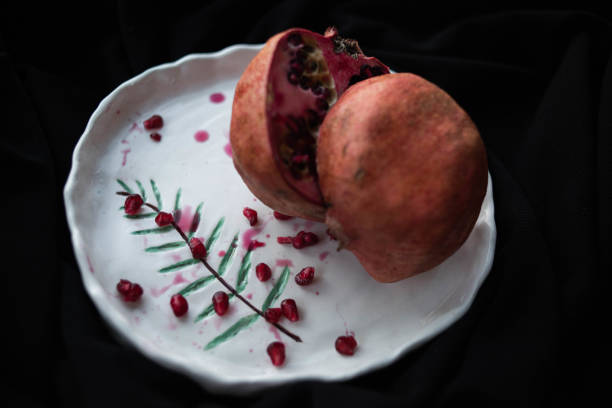 istock Cut in the middele of pomegranate on ceramic plate 1210731082