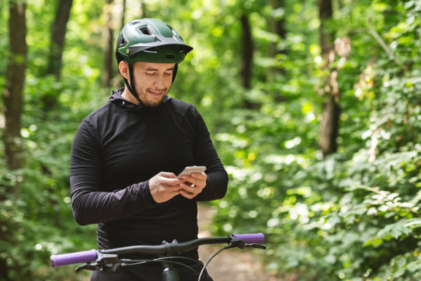 istock Happy cyclist holding smartphone, checking on messages 1210732071