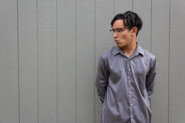 istock Mixed race millennial man, lips pursed in profile, hands behind back, open copy space 1210732211