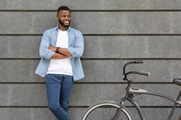 istock Young black guy posing next to bicycle over urban concrete wall 1210736042