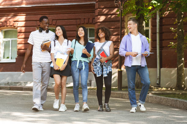 istock Group of students walking outdoors in university campus together 1210736747